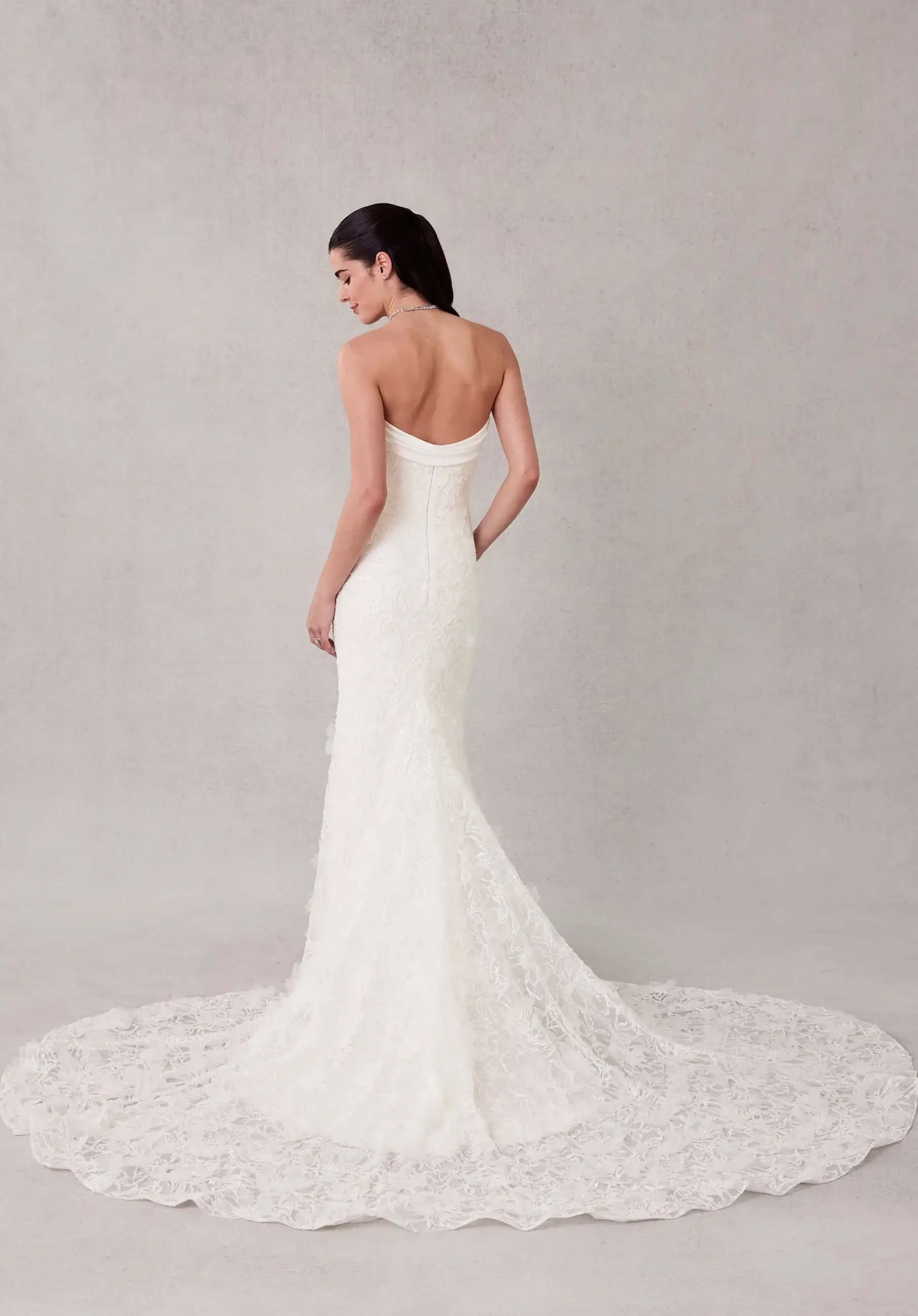 model is wearing a strapless fit and flare bridal gown with a draped cowl detail by morilee