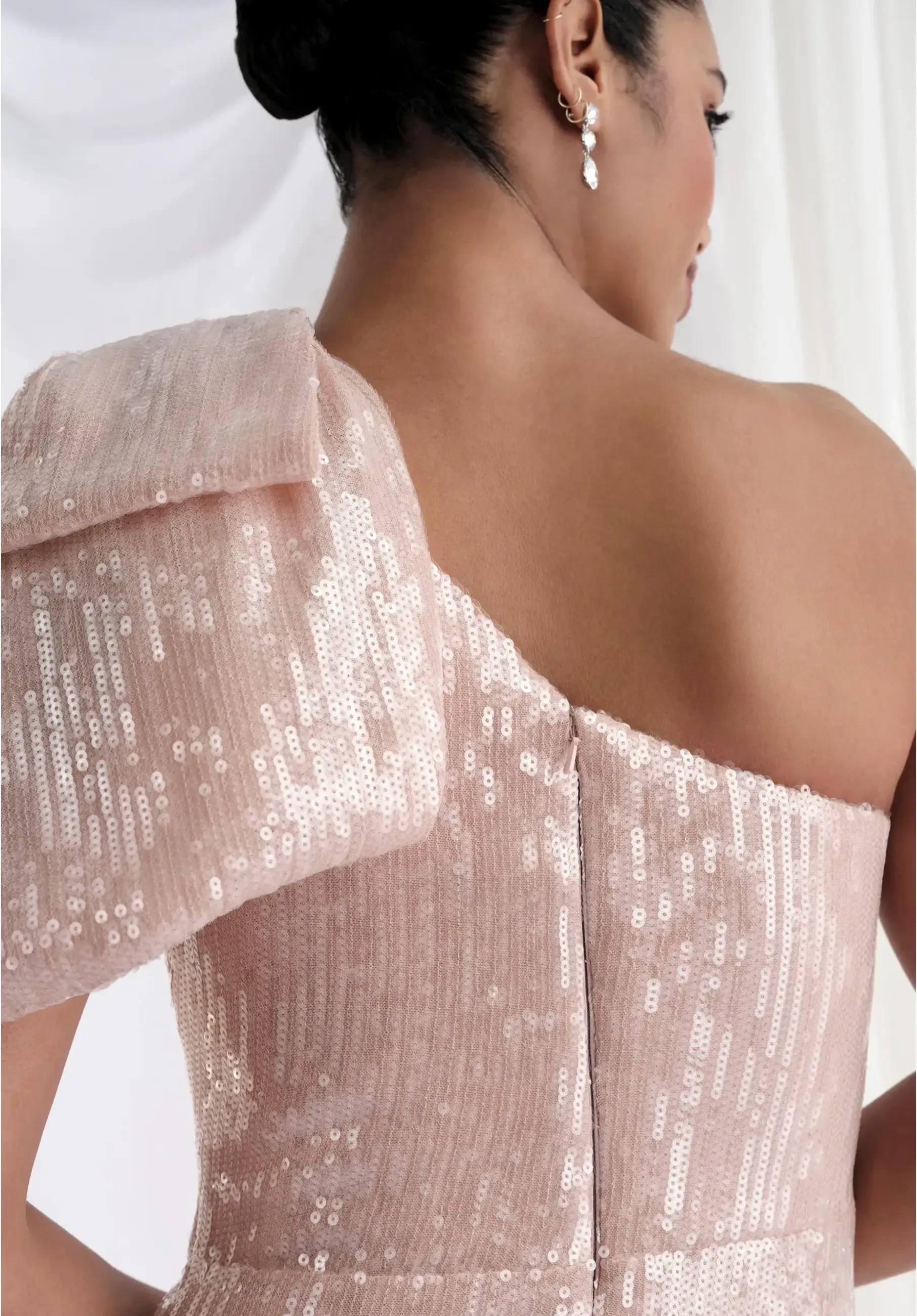 model is wearing a one shoulder light pink mother of the bride dress