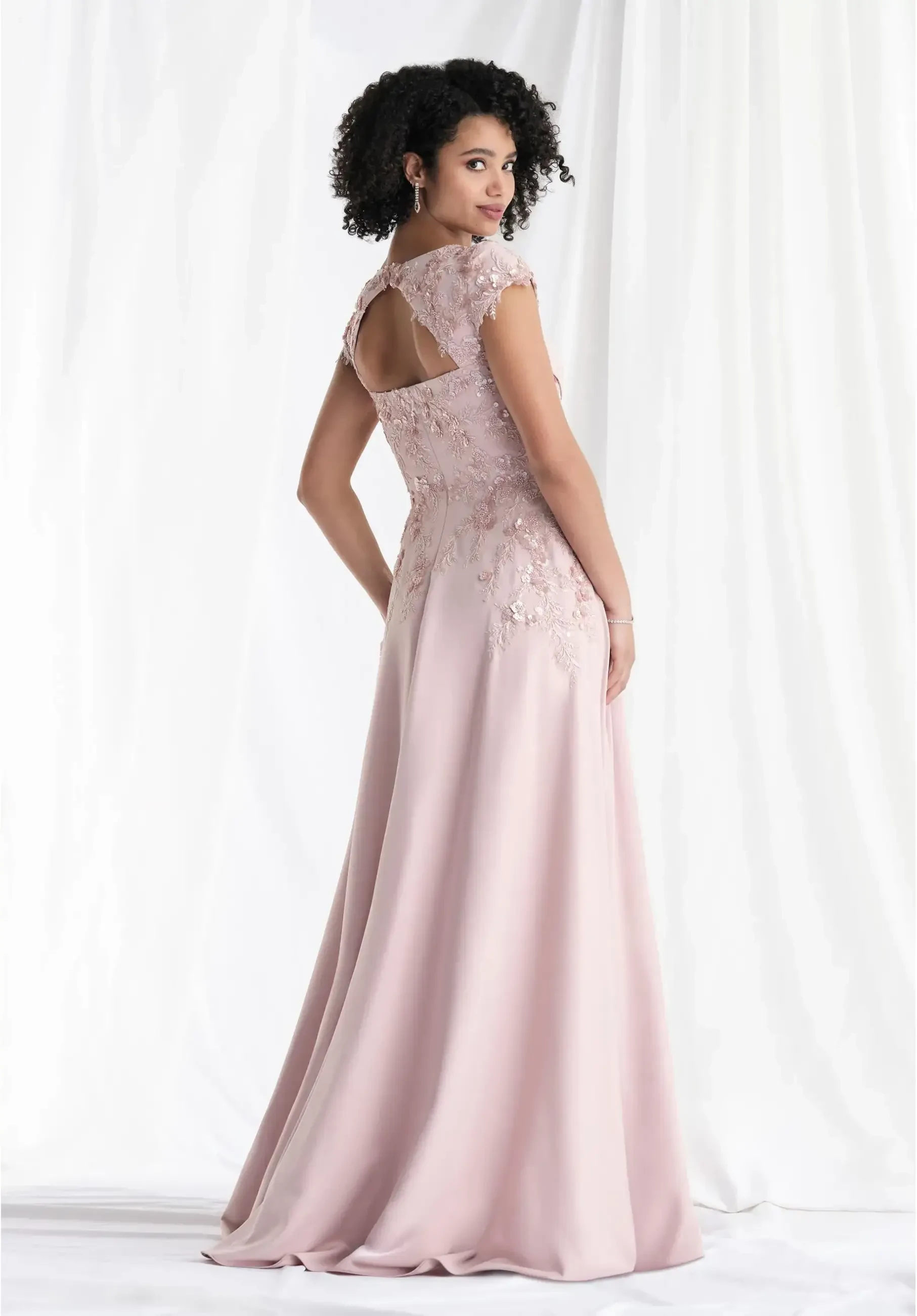 model is wearing a light pink cap sleeve mother of the bride dress
