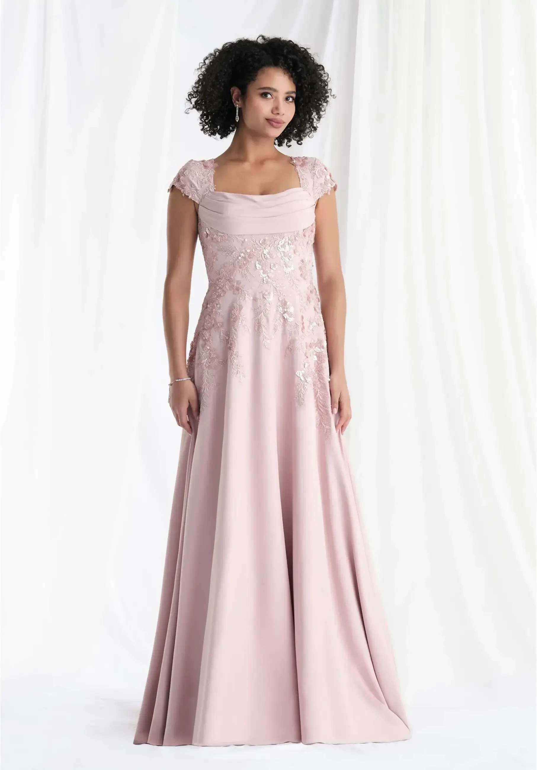 model is wearing a light pink cap sleeve mother of the bride dress