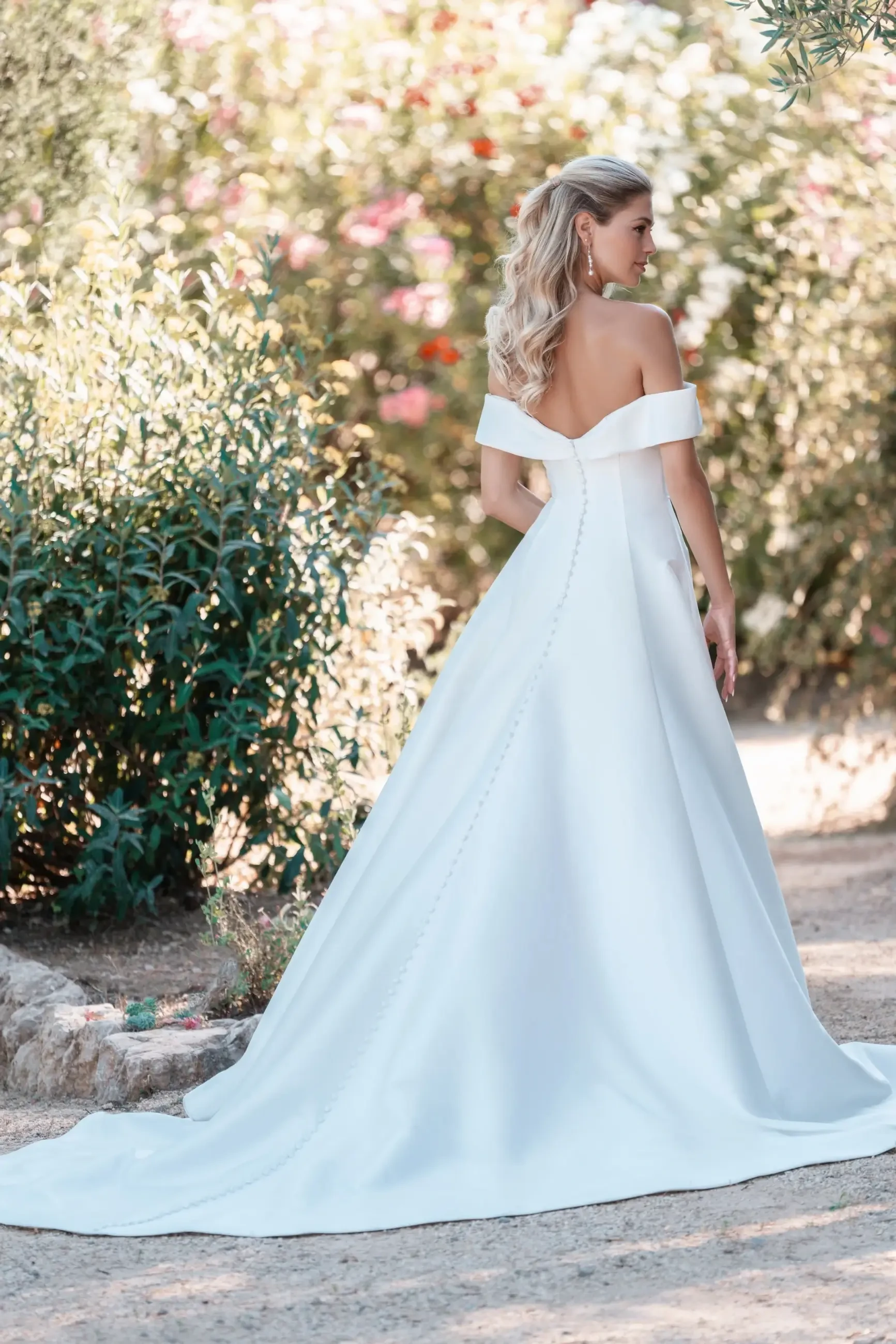 model is wearing a mikado a-line off the shoulder wedding dress by allure bridals