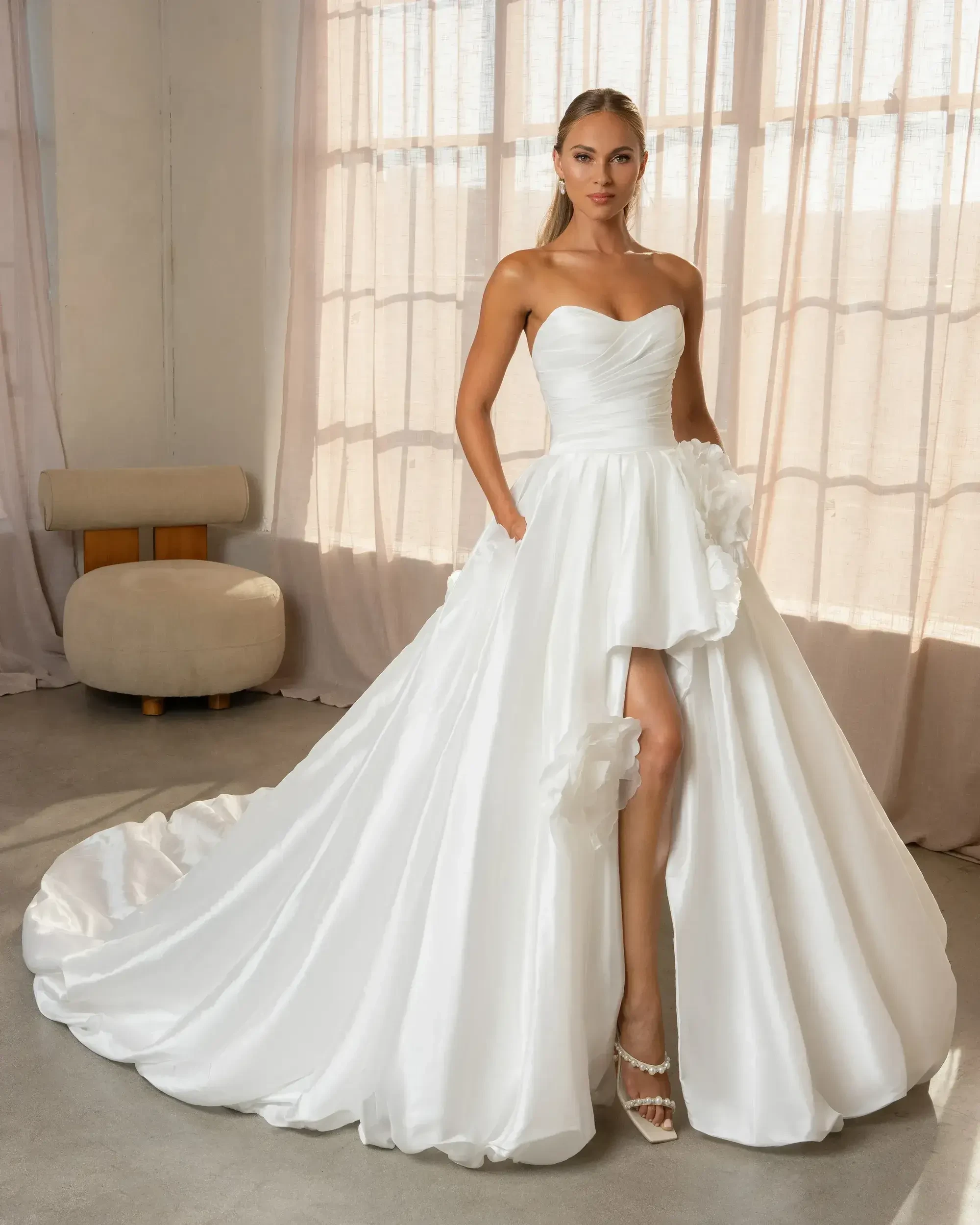 model is wearing a bridal gown with a slit